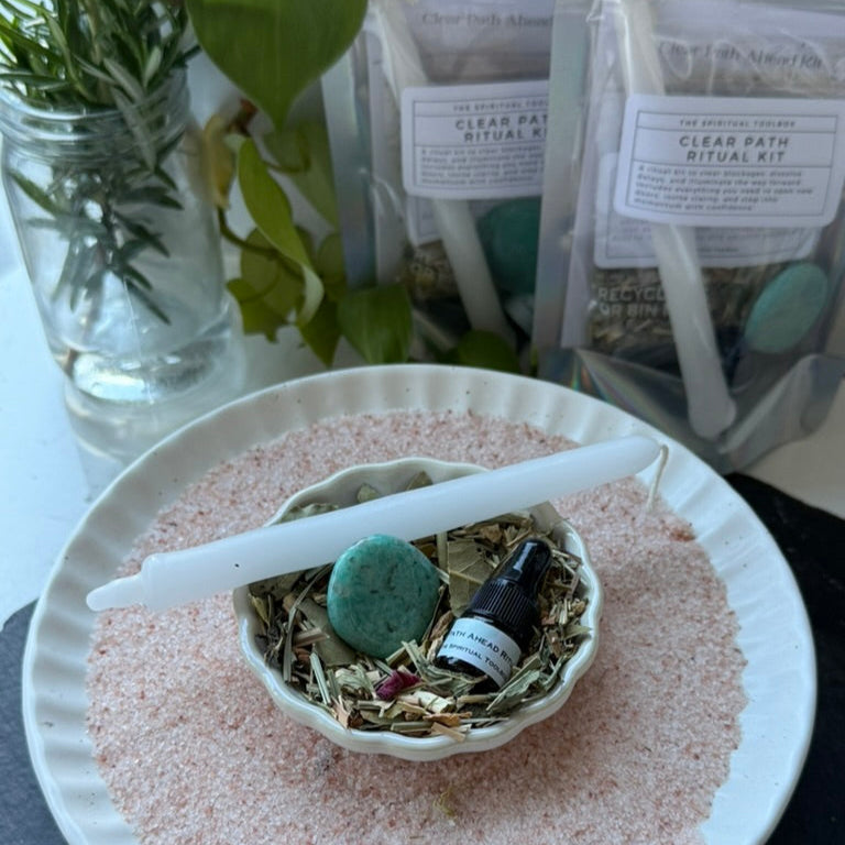 Herbal mix, bottle, and green stone on a white plate with plants and packages in the background.