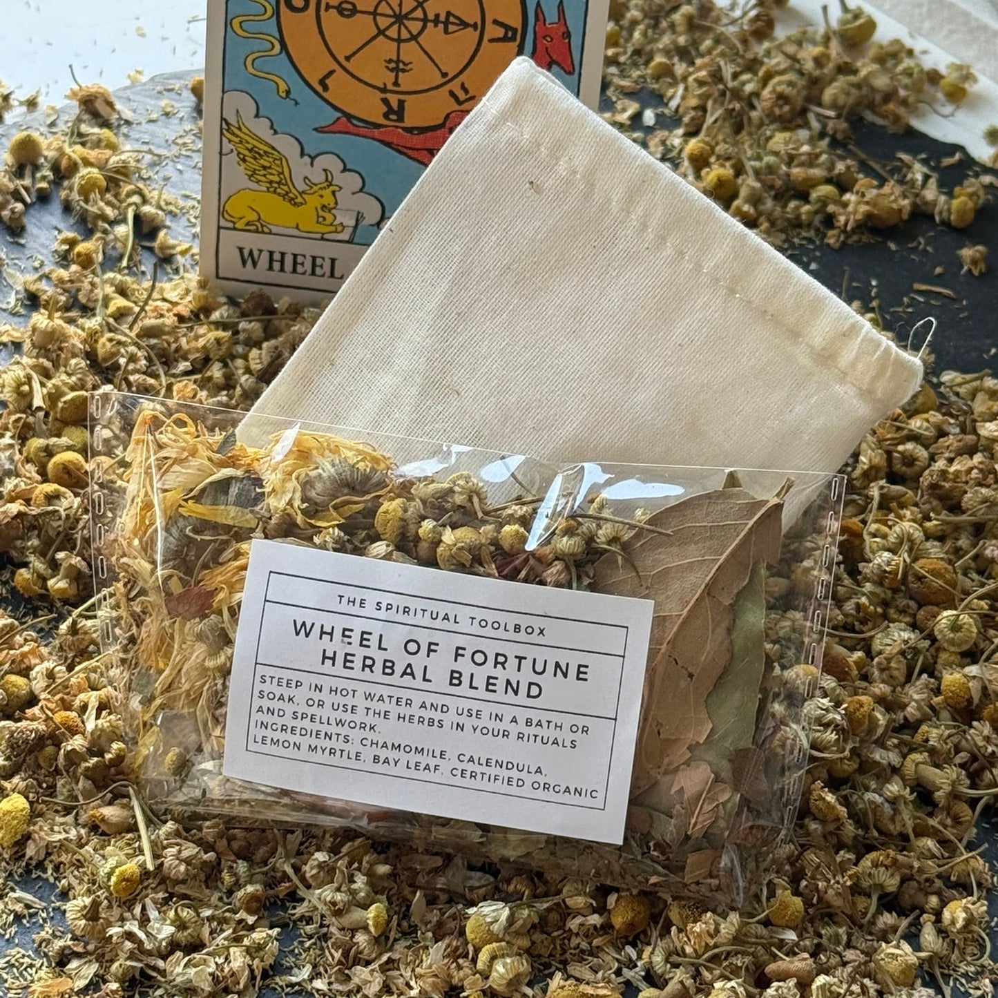 Herbal blend package with tarot card and dried herbs on a textured surface