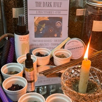Herbal remedies and a candle on a table with 'The Dark Half' book in the background