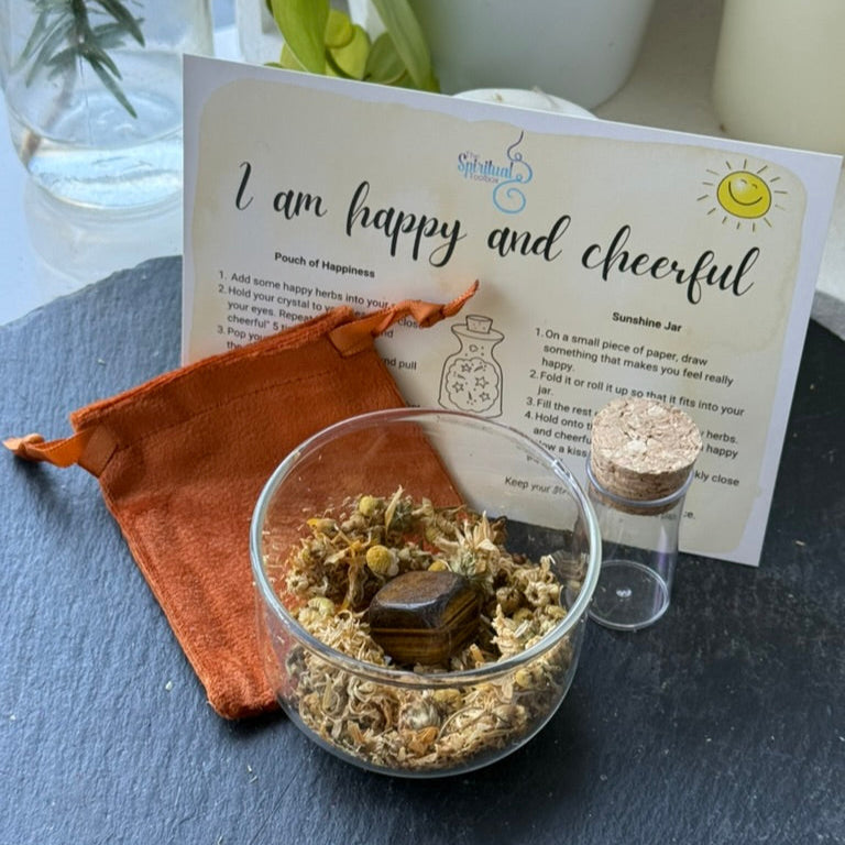 Glass jar with herbs, orange pouch, and card on a dark surface