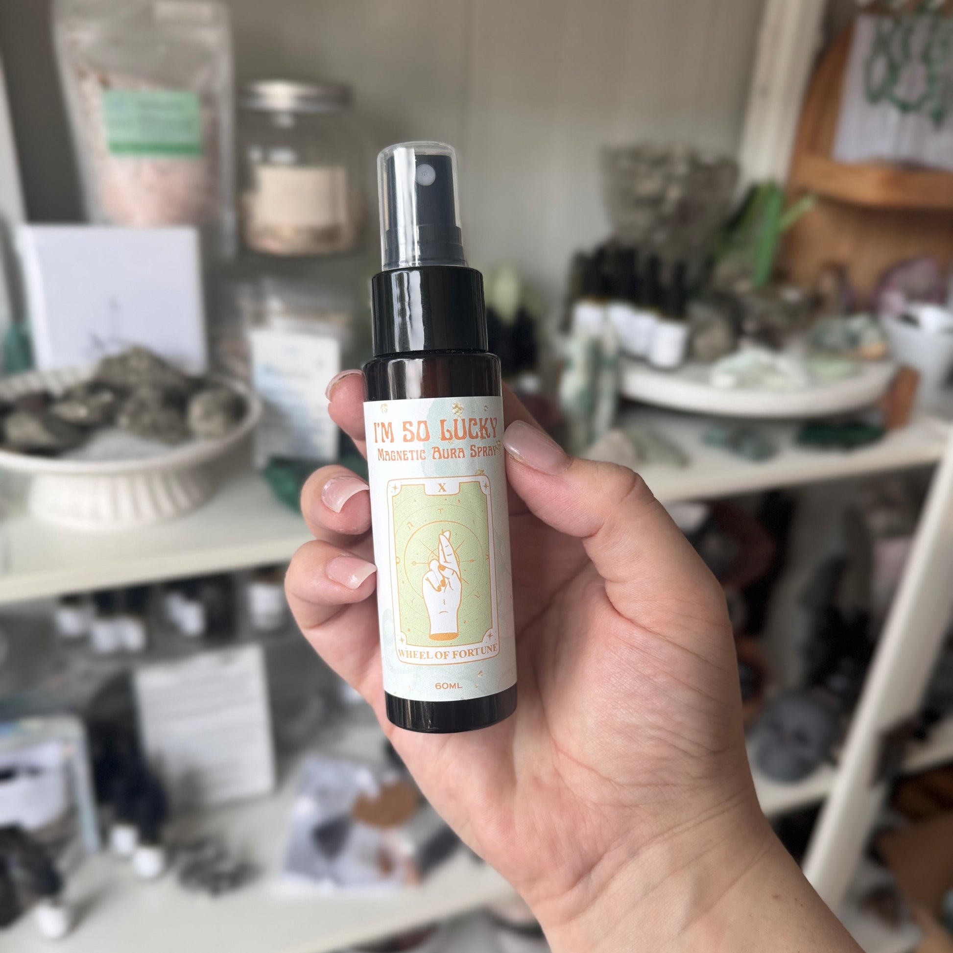 Hand holding a small bottle with a label in an indoor setting