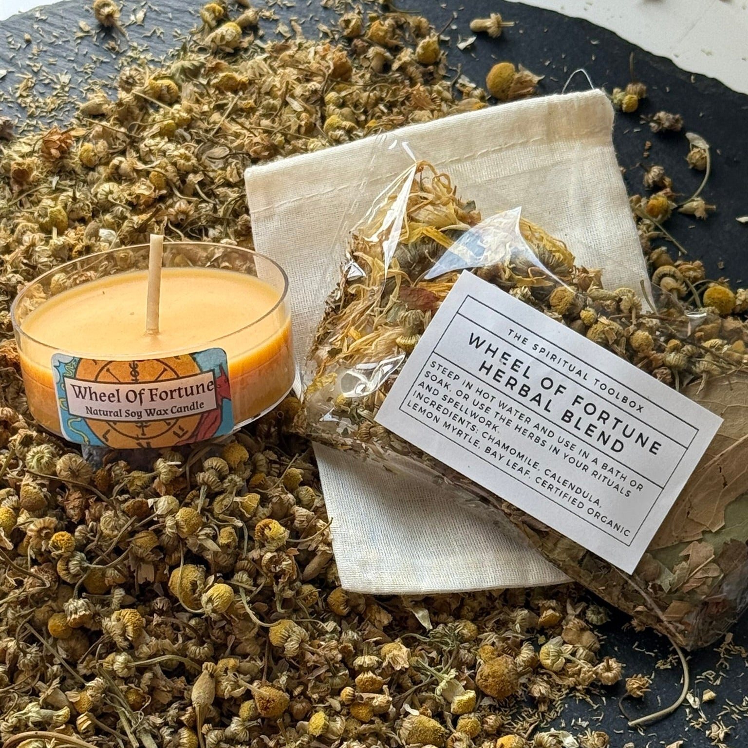 Wheel of Fortune candle and herbal blend on a dark surface with dried herbs.