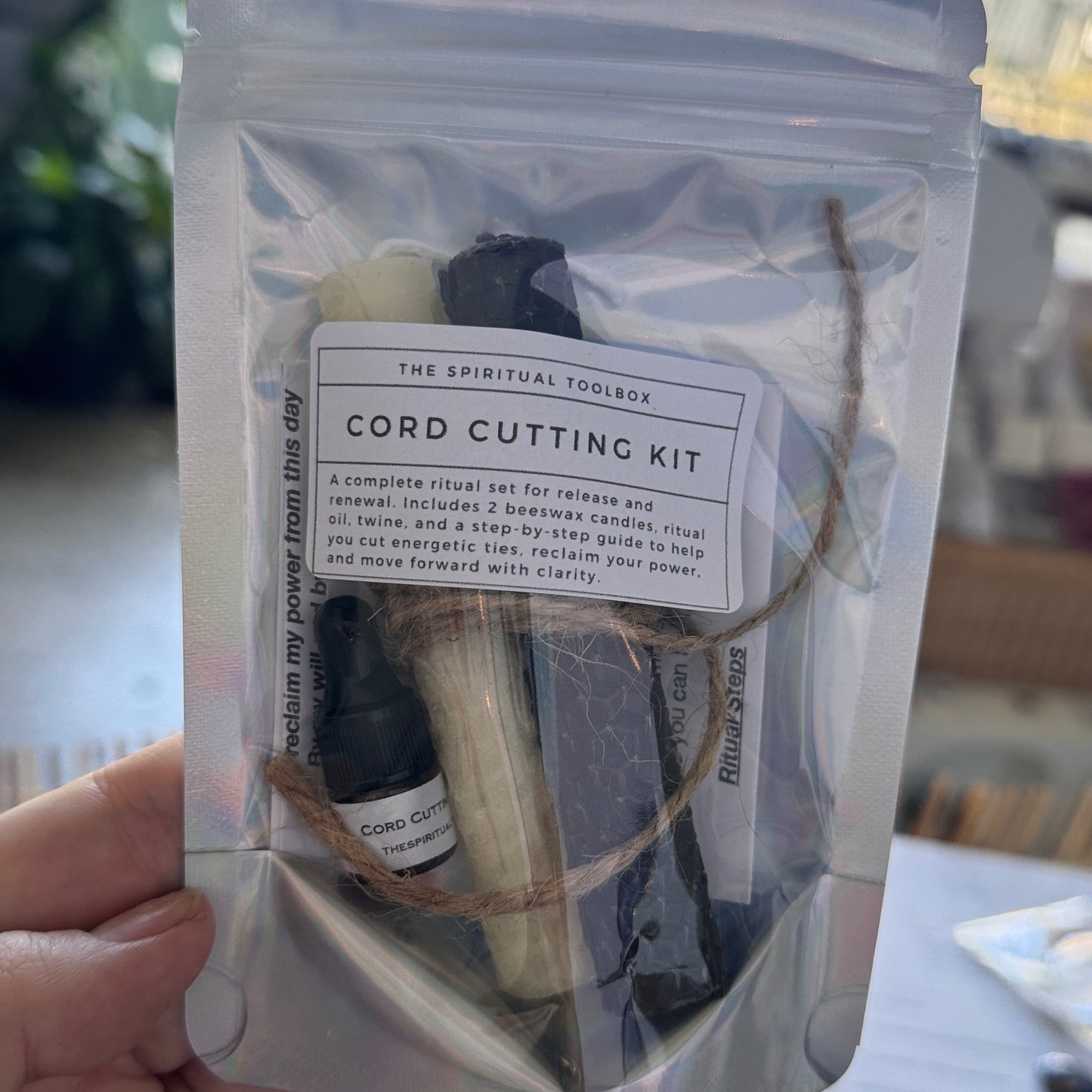 Cord cutting kit in a clear plastic bag held by a hand with a blurred background