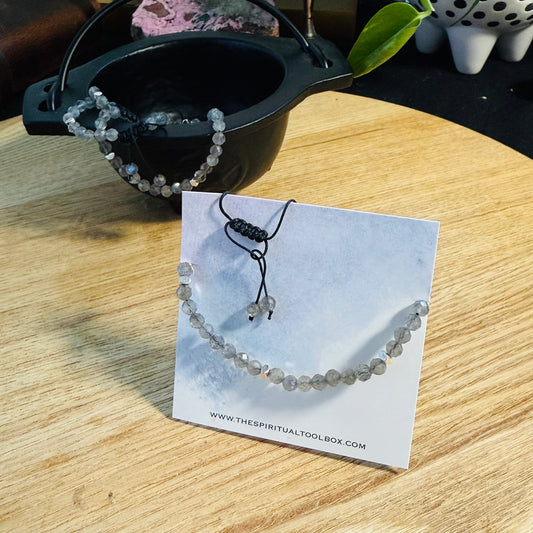 Beaded bracelet on a card with cauldron in the background