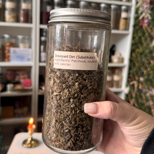 Hand holding a jar of dried herbs with a apothecary the background