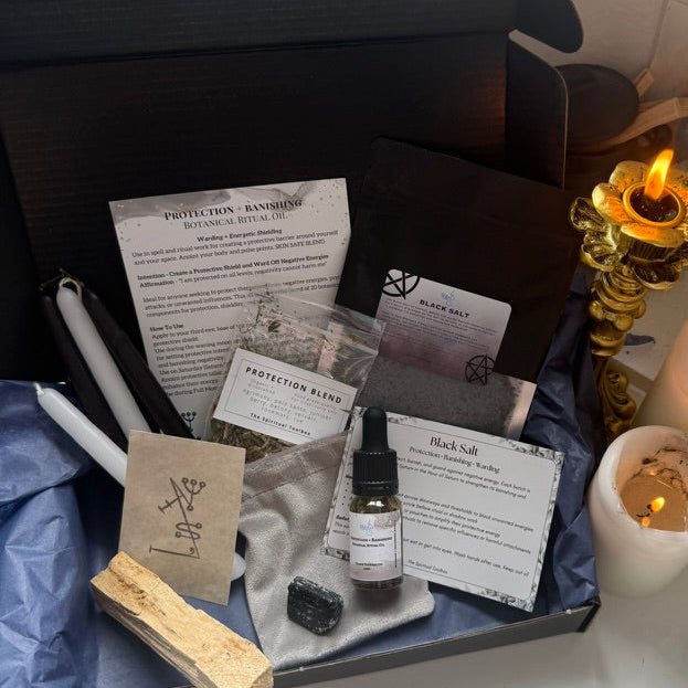Box with items including a bottle, papers, and a candle on a table.